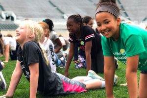 Girls laughing while stretching during ACES Day